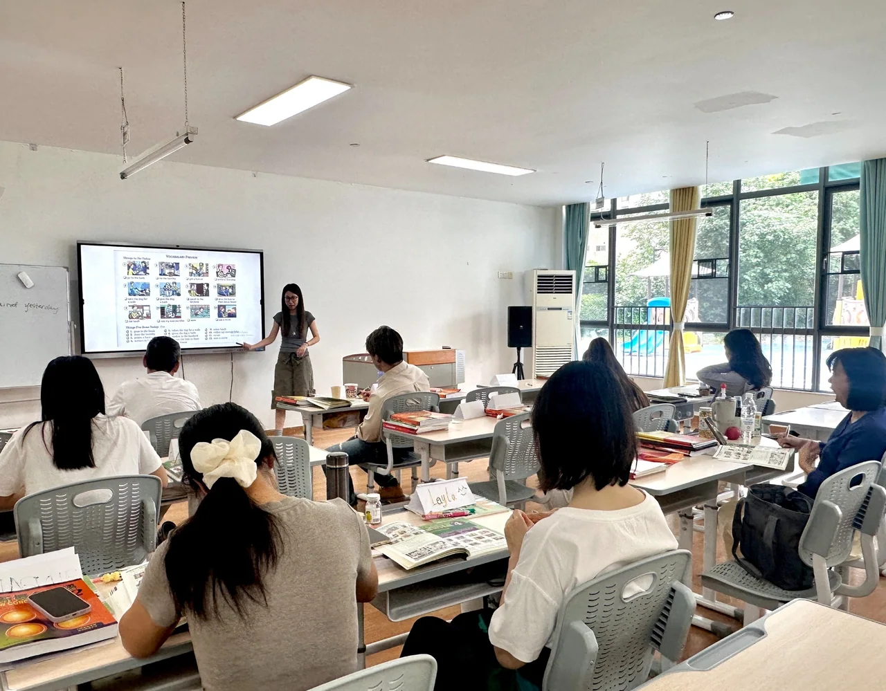 赛思中教课堂，教师结合屏幕内容讲解，学员在座位上学习